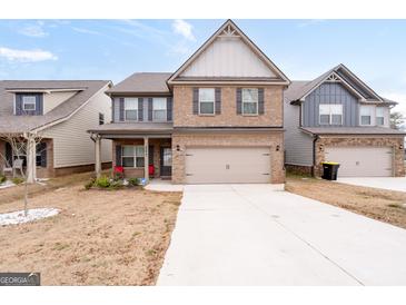 Charming two-story home with brick and siding, two-car garage, and well-maintained lawn at 2277 Church St, Hampton, GA 30228