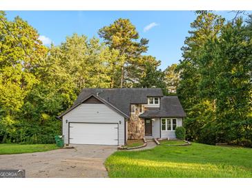 Charming home featuring stone accents, gray siding, and mature trees surrounding the property at 5368 Nw Stafford Nw Dr, Lilburn, GA 30047