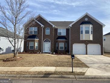 Traditional brick two-story home with a well-manicured lawn and attached two-car garage at 1238 Polk Xing, Mcdonough, GA 30252