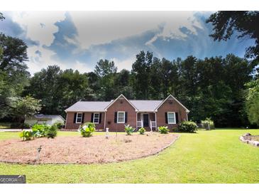 Charming brick home with a well-manicured lawn and complementary landscaping at 155 Granby Ln, Fayetteville, GA 30215