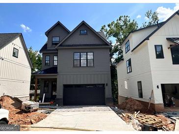 New construction two-story home with a dark garage door and neutral-colored siding at 3024 Trae Ct, Smyrna, GA 30080