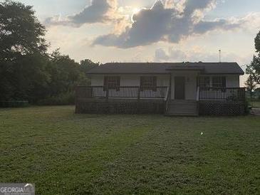 Inviting single-story home with a spacious front deck and a well-maintained lawn at 276 Oakland Rd, Mcdonough, GA 30253