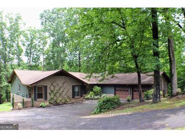 Charming brick home featuring a two-car garage and lush landscaping, creating an inviting curb appeal at 1310 Larkview Sw Dr, Lilburn, GA 30047