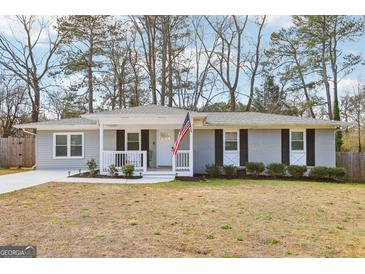 Charming single-story home featuring neutral paint, shutters, a cozy porch, and an American flag at 456 Pretty View Se Ln, Smyrna, GA 30082