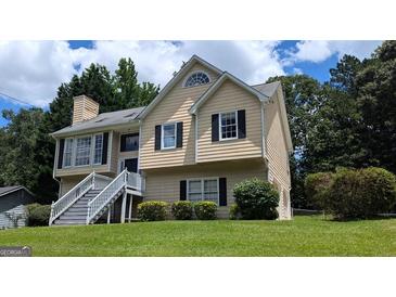Charming two-story home with a well-maintained lawn, welcoming staircase, and black shutters at 9230 Melody Sw Cir, Covington, GA 30014