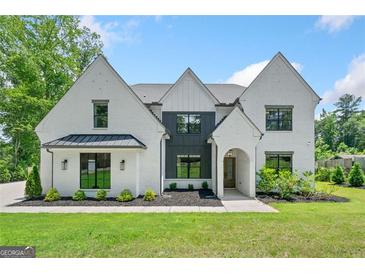 Beautiful two-story home with a well-manicured lawn, brick exterior, and elegant front facade at 103 Maddox Rd, Buford, GA 30518