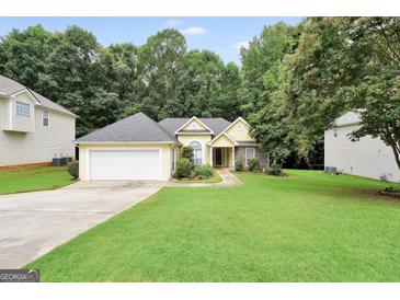 Charming single-story home with a well-manicured lawn and attached two-car garage at 1335 Vine Cir, Mcdonough, GA 30253