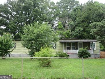 Cozy single-story home with a covered porch and partially-wooded front yard at 4 Skyland W Dr, Locust Grove, GA 30248