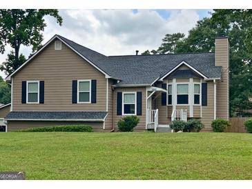 Charming single-Gathering home with a well-maintained front yard, inviting curb appeal, and bay window at 565 Scarborough Rd, Ellenwood, GA 30294