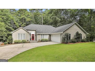 Charming home with a well-manicured lawn and a bright red front door surrounded by lush trees at 118 Whitfield Run, Peachtree City, GA 30269