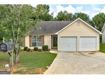 Charming single-story home with a two-car garage, well-maintained lawn, and mature landscaping at 2898 Cedar Trace Dr, Ellenwood, GA 30294