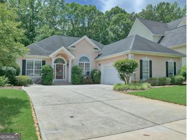 Charming single-story home featuring a well-manicured lawn, inviting entrance, and a spacious driveway at 183 Eagles Club Dr, Stockbridge, GA 30281