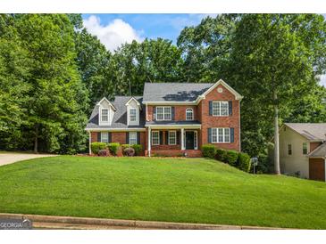 Charming two-story brick home with a well-manicured lawn and mature trees creating a serene setting at 1048 Falls Brooke Dr, Conyers, GA 30094