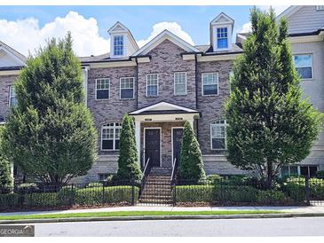 Charming three-story brick townhouse with well-manicured landscaping and a classic, symmetrical facade at 4107 Township Pkwy # 69, Sandy Springs, GA 30342