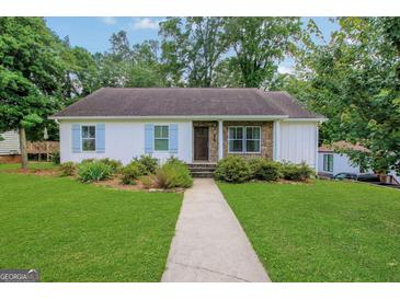 Charming single-story home with a lush lawn, stone accents, and inviting walkway at 792 Mimosa Se Dr, Marietta, GA 30060