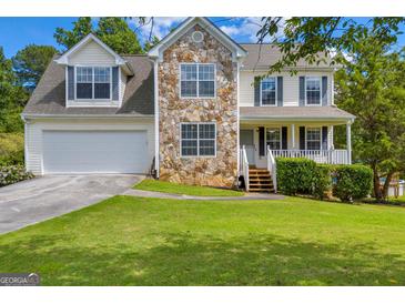 Charming two-story home with stone accents, manicured lawn, and attached two car garage at 684 Doe Lane Ln, Loganville, GA 30052