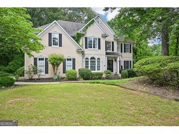 Charming two-story home with a manicured front yard, lush landscaping, and black shutters, giving great curb appeal at 1285 Willow Park Way, Cumming, GA 30041