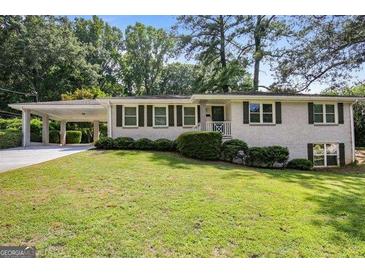 Charming single-story home featuring a white brick facade, covered carport, and a well-maintained lawn at 2855 Briarlake Ne Rd, Atlanta, GA 30345