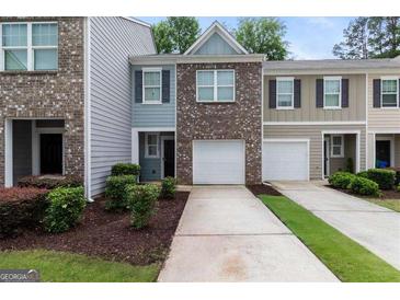 A brick townhouse with attached one car garage and lush landscaping at 3155 Tarian Way, Decatur, GA 30034