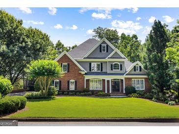 Stately brick and gray home with lush green lawn, offering classic curb appeal and mature landscaping at 125 Franklin Pl, Atlanta, GA 30342