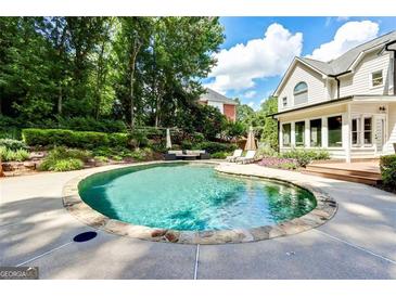 Backyard pool features a stone surround and patio furniture at 121 Fairway Overlook, Woodstock, GA 30188