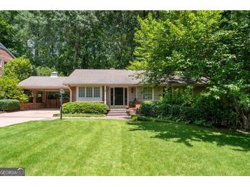Charming ranch home with a well-manicured lawn, lush landscaping, and a convenient carport at 2917 Rockingham Nw Dr, Atlanta, GA 30327