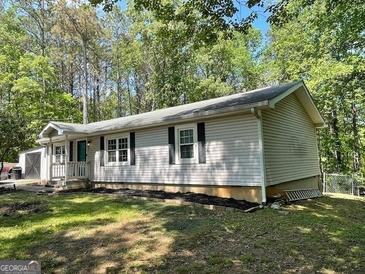 Charming single-story home with manicured lawn and mature trees, offering a serene and inviting atmosphere at 324 Bells Ferry Ne Rd, White, GA 30184