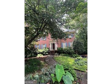 Charming brick home with lush landscaping, blue shutters, and a welcoming front entrance at 974 Bloomfield Dr, Lawrenceville, GA 30044