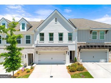 Beautiful townhome featuring a painted brick facade, two-car garage, and manicured landscaping at 1316 Willamette Way, Marietta, GA 30008