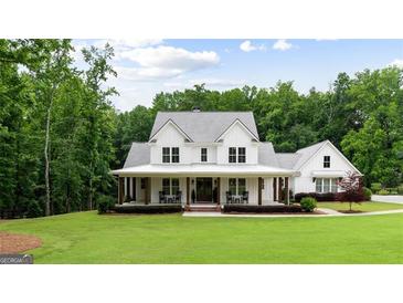 Charming white farmhouse with a welcoming front porch and professionally landscaped yard at 2101 Thomas Rd, Canton, GA 30115