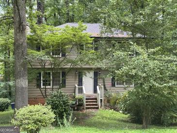 Two-story home exterior with mature trees, dark shutters, and a white front door at 372 Nalley Dr, Stone Mountain, GA 30087