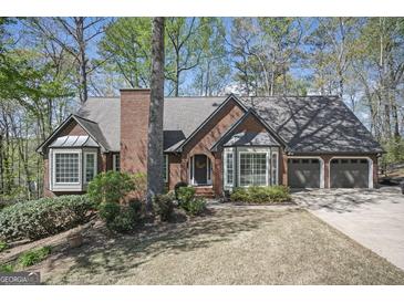 Charming brick home featuring a well-manicured lawn, bay windows, and an attached two car garage at 2689 Spring Rock Ne Ct, Roswell, GA 30075
