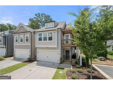 Charming two-story townhome featuring an attached garage and a quaint second story balcony at 774 Belrose Dr, Smyrna, GA 30080
