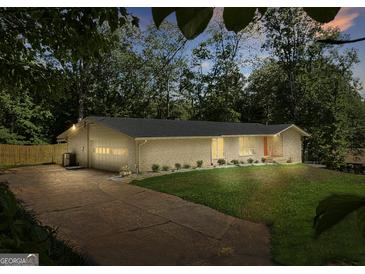 Charming one-story brick home with a well-manicured lawn and attached two car garage at 3332 Saint John Dr, East Point, GA 30344