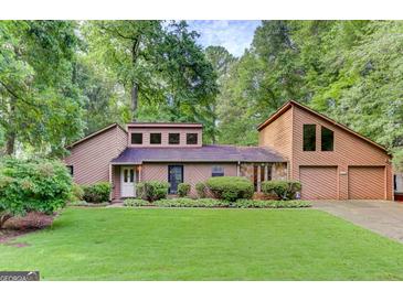 Charming two-story home with a well-manicured lawn, stone accents, and an attached two-car garage at 4920 Tremont Ne Dr, Marietta, GA 30066