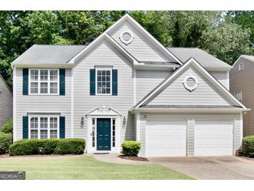Charming two-story home with a well-manicured lawn, blue shutters, and an attached two-car garage at 2821 Amhurst Nw Way, Kennesaw, GA 30144