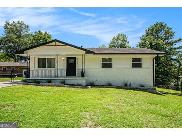 Charming home featuring a well-manicured lawn and freshly painted exterior, complete with black trim accents at 4020 Ester Sw Dr, Atlanta, GA 30331