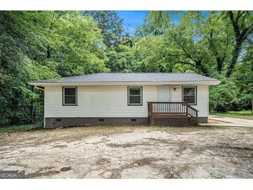 Charming single-story home featuring a quaint front porch and a serene, tree-lined backdrop at 114 Howell Dr, Atlanta, GA 30331