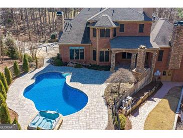 Beautiful backyard pool and patio area with lounge and a connected hot tub at 297 Collegiate Dr, Powder Springs, GA 30127