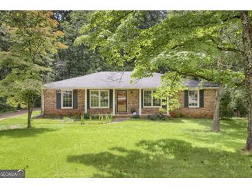 Charming brick home with mature trees and a lush, well-maintained front lawn at 3180 S Elizabeth Dr, Douglasville, GA 30135