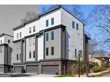 Modern townhome with a two-car garage and mixed material exterior, including light gray siding and brick at 1836 Memorial Dr # 303, Atlanta, GA 30317