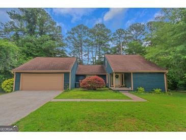 Charming home with a two-car garage, complemented by a well-manicured lawn and vibrant shrubbery at 959 Sweet Briar Se Trl, Conyers, GA 30094