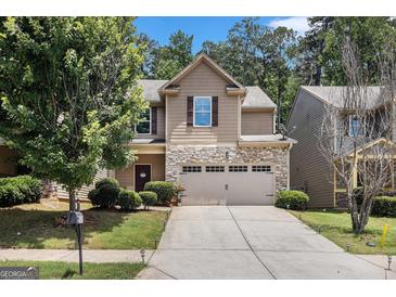Charming home featuring a stone facade, a two-car garage, and lush landscaping at 2780 Lakeview Walk, Decatur, GA 30035