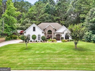 Charming one-story home featuring stone accents, mature landscaping, and a spacious front yard at 264 Line Creek Cir, Sharpsburg, GA 30277