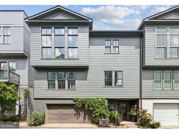 Modern townhome features a gray exterior, large windows, and attached garage with ivy climbing the facade at 698 Eustace Se St, Atlanta, GA 30315