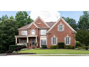 Charming brick home featuring manicured lawn, complementing shrubbery, and a welcoming entrance at 200 Long Needle Ct, Sugar Hill, GA 30518