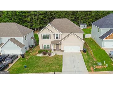 Two-story home featuring a two-car garage, manicured lawn, and neutral-toned siding at 232 Shelton Cir, Temple, GA 30179
