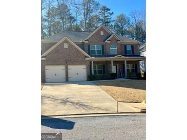 Traditional brick home with attached two car garage, covered porch, and well maintained lawn at 2208 Ginger Lake Ne Dr, Conyers, GA 30013