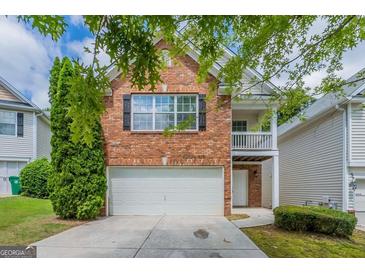 Charming two-story brick home with a well-maintained lawn and attached garage in a quiet neighborhood at 513 Shadow Valley Ct, Lithonia, GA 30058