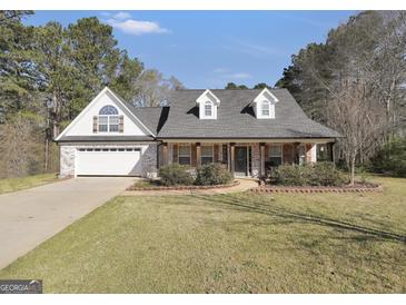 Charming home featuring a brick and siding facade, gabled roof, and manicured landscaping at 950 Besse Way, Locust Grove, GA 30248